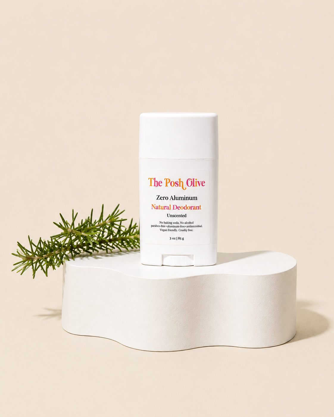 The Posh Olive zero aluminum natural deodorant in a white tube displayed on white pedestal with greenery