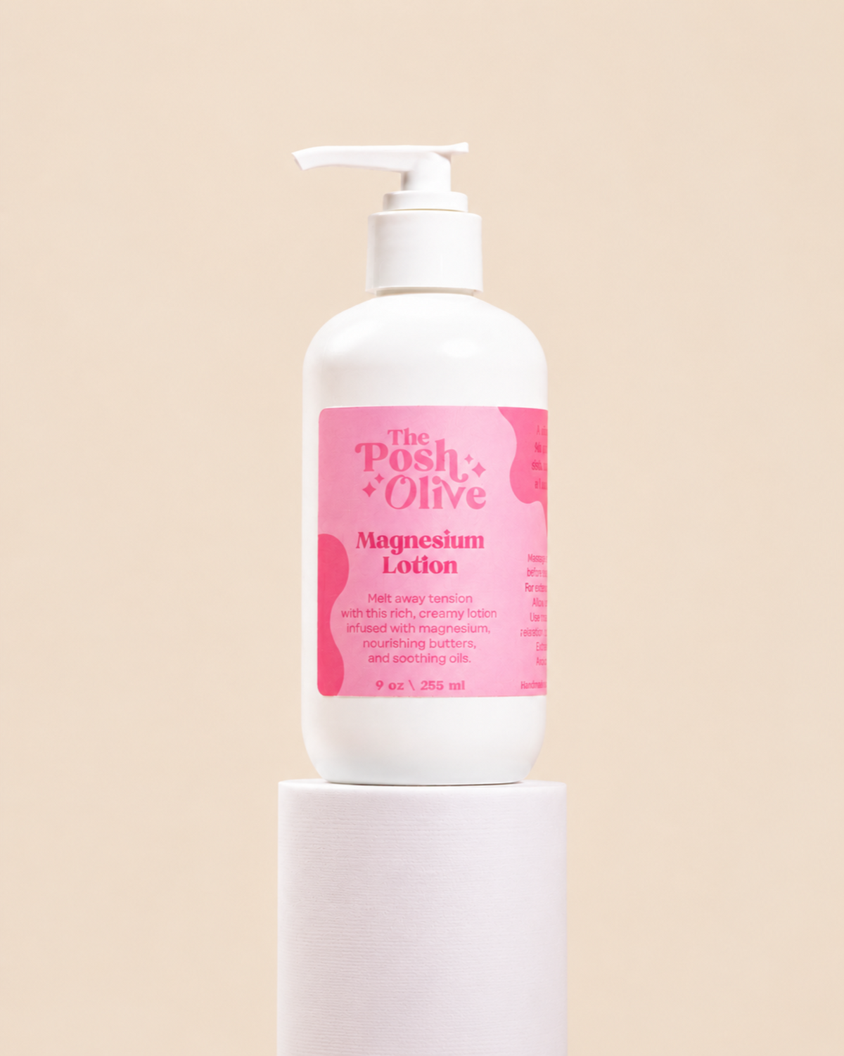 A white pump bottle of The Posh Olive Magnesium Lotion with a pink label, displayed on a white cylindrical pedestal against a solid beige background.