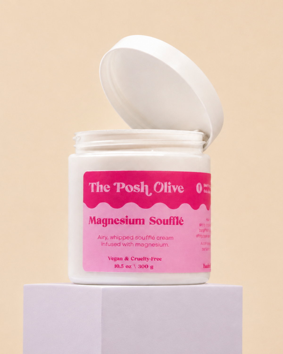 The Posh Olive Magnesium Soufflé in open jar displayed on white pedestal