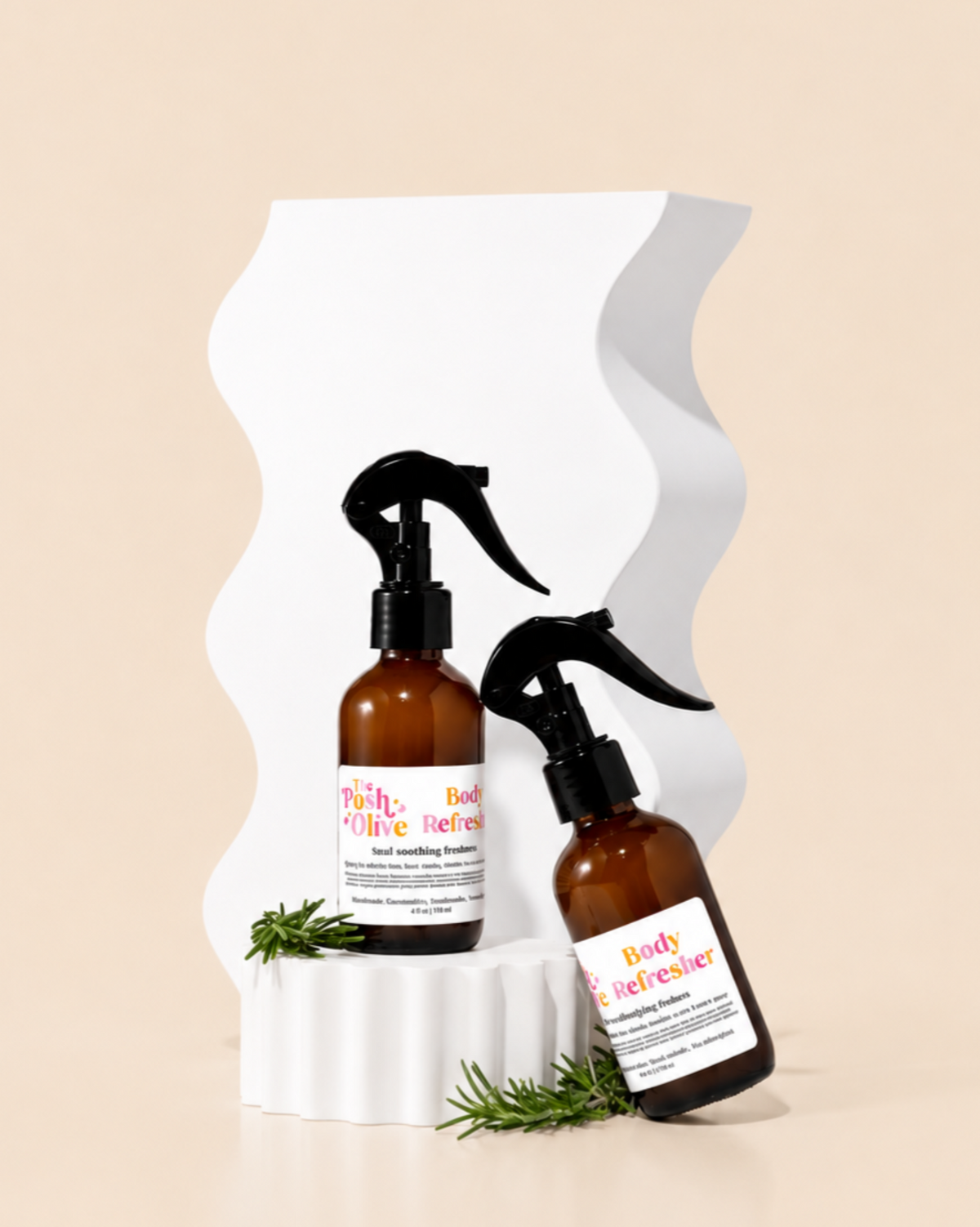 The Posh Olive Body Refresher sprays in amber bottles displayed on white pedestal